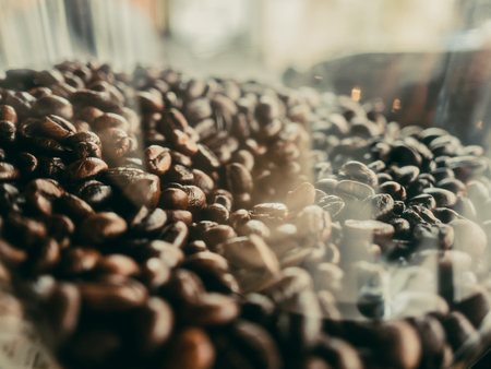 Coffee beans in transparent plastic container.の写真素材