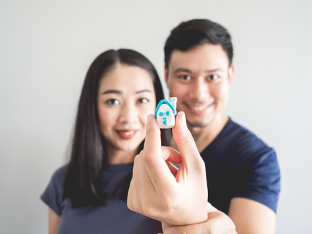 Happy couple lover showing small house in hand. Concept of buying house to start a family.の写真素材