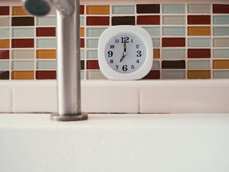Simple white clock in the bathroom. Concept of life routine.の写真素材