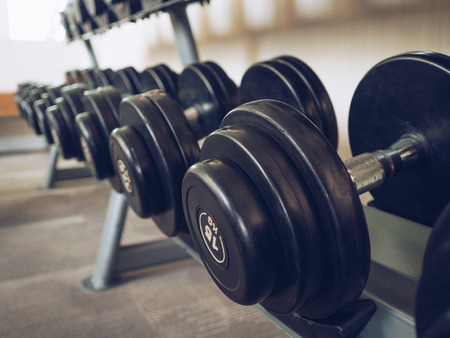 Dumbells set left on the racks in the gym.の写真素材