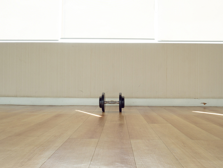One dumbell left alone on the floor in the gym.の写真素材