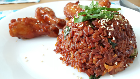 Homemade kimchi fried rice with fried chicken drumsticks.の写真素材