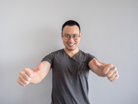 Happy Asian freelance man with skinhead and relaxing mile haircut.の写真素材