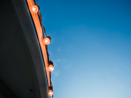 Light blubs decorated on the roof edge at evening time.