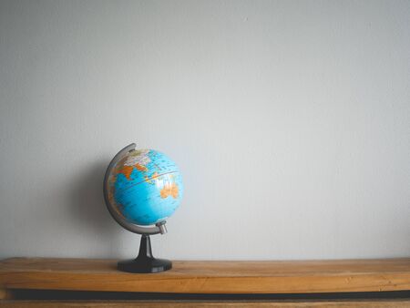 Small desk globe map on wooden table.の写真素材