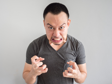 Angry asian man portrait with funny mad face.