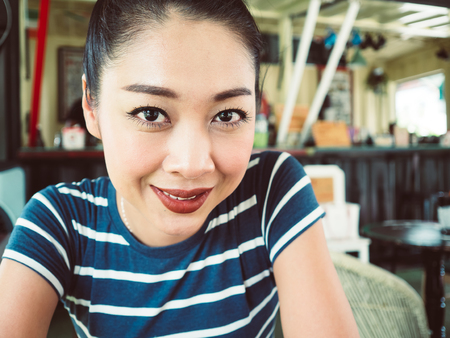 Asian woman in drink and relax in coffee cafe.の写真素材