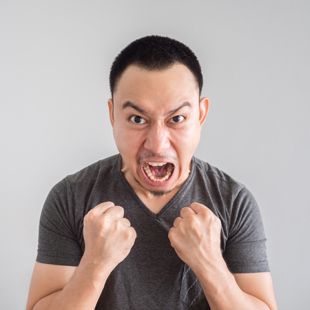 Angry and crazy asian man in black t-shirt and skinhead hair style.の写真素材