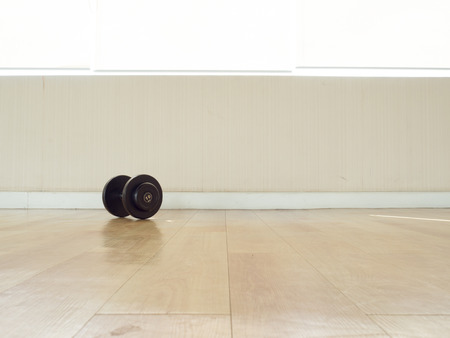 One dumbbell left alone on the floor in the gym.の写真素材