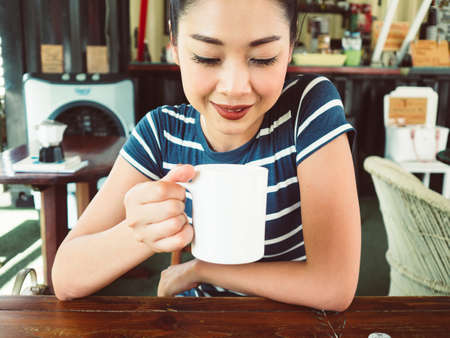 Asian woman in drink and relax in coffee cafe.の写真素材