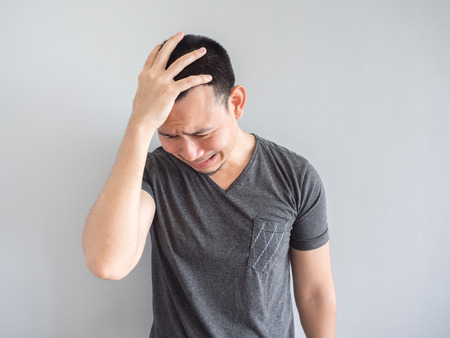 Crying asian man in black t-shirt.の写真素材