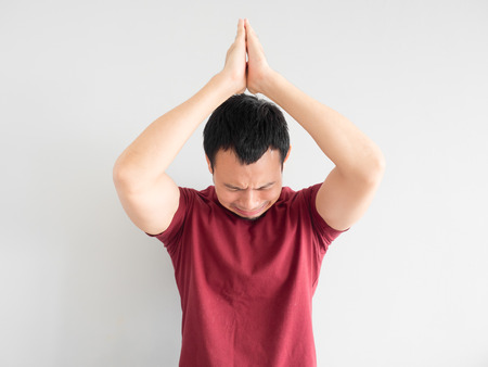 Crying Asian man asking for forgiveness or begging the god for good fortune.