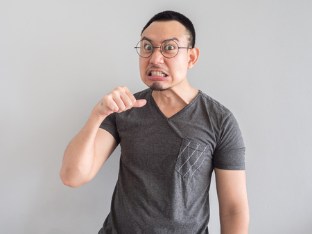 Angry and crazy asian man in black t-shirt and skinhead hair style.の写真素材