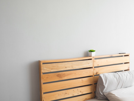 Wooden board of top bed with pot plant and empty wall.の写真素材