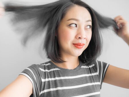 Asian woman playing with her short hair.の写真素材