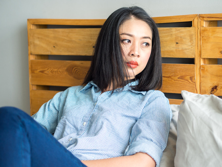 Portrait of Asian woman relaxs on bed in day time.