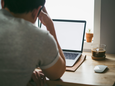 Asian man work on his laptop get serious with his deadline.の写真素材