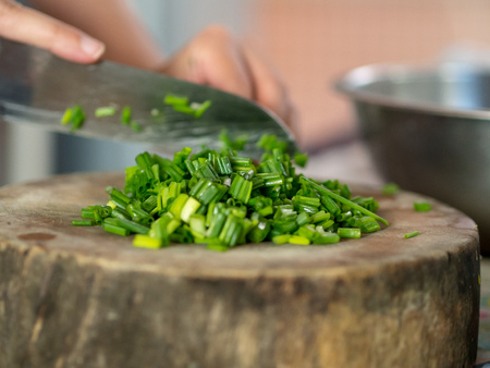 Hand cut Scallions on wooden cutting board.の写真素材