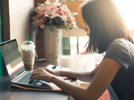 Asian woman is working on laptop in coffee cafe.の写真素材