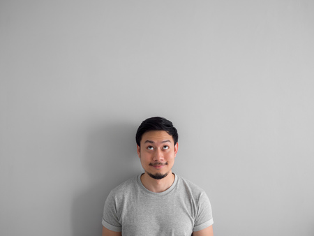 Happy face of Asian man with beard in grey t-shirt.
