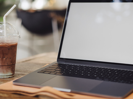 Laptop and iced coffee in the cafe. Concept of freelance working and relax.の写真素材