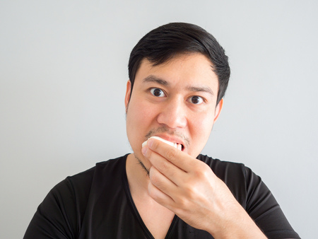 Close up of Asian man is eating Mochi style snack.