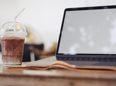 Laptop and iced coffee in the cafe. Concept of freelance working and relax.の写真素材