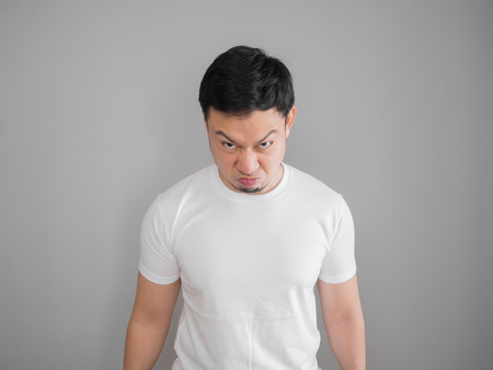 Very angry aggressive Asian man portrait in white t-shirt.の写真素材