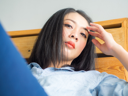 Portrait of Asian woman relaxs on bed in day time.の写真素材