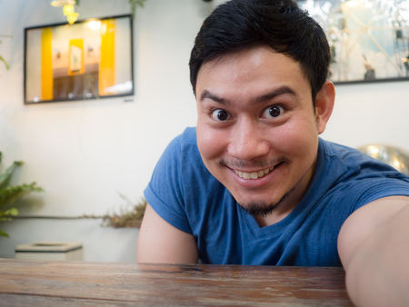 Asian man selfie himself on the table in the cafe and restaurant.