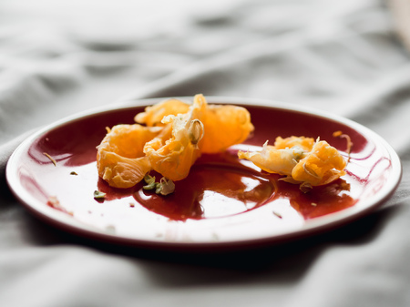 Some left over of orange in red dish on bed on good relax day.の写真素材