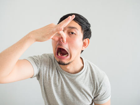 Funny face of bad breath Asian man.の写真素材