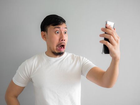Shocked and scary face of Asian man get yelled from smartphone.  See something scary in smartphone.の写真素材