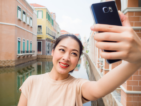 Asian woman tourist is taking selfie photo from the smartphone.の写真素材