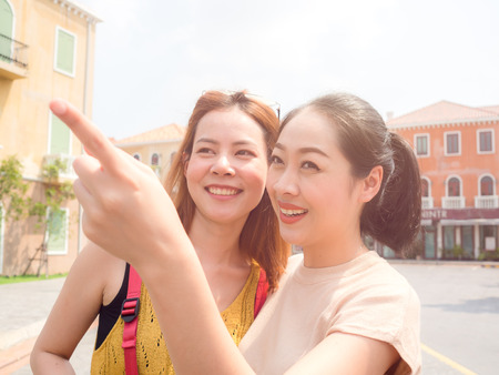 Two Asain women tourists best friends are walking down on the street in europe for sightseeing trip.の写真素材