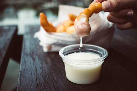 Close up of Deep fried Doughsticks with condensed milk.の写真素材