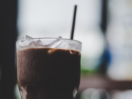 Close up of a glass of Iced Cocoa cool drink served on table.の写真素材