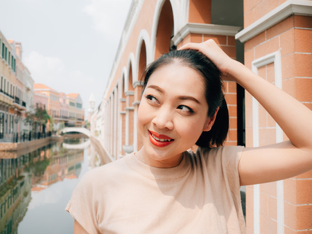 Portrait of Asian tourist girl in bright sun of summer in travel destination.の写真素材