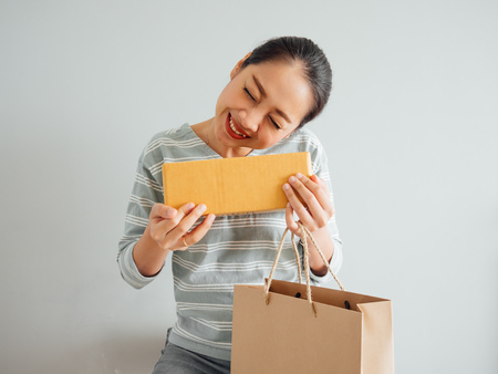 Asian woman is feeling happy and surprised with the online purchursed product and survice. Concept of happy online shopping business.の写真素材