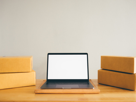Mockup of white empty display laptop with boxes. Concept of online business.