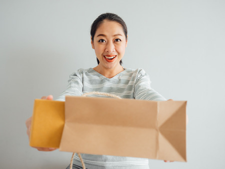 Asian woman is feeling happy and surprised with the online purchursed product and survice. Concept of happy online shopping business.の写真素材