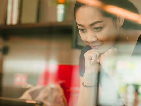 Asian woman works with tablet in the coffee cafe.