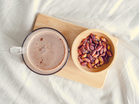 Small snacks set of salted beans and hot chocolate served on the bed in the morning.の写真素材