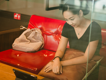 Asian woman works with tablet in the coffee cafe.の写真素材