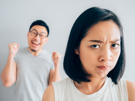 Annoyed Asian wife and funny tricky husband.の写真素材