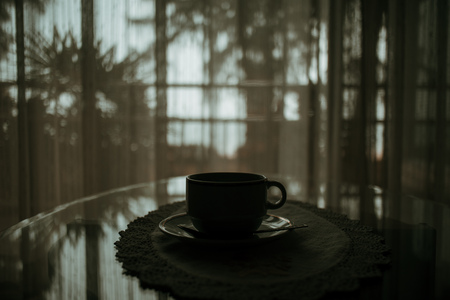 Silhouette of hot coffee cup on table in the house.