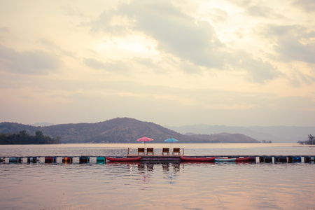 Chair and umbrella with beautiful lake and mountain landscape.