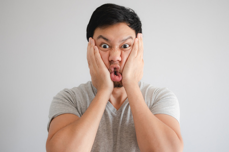 Funny face of angry Asian man punish himself by hit on his own face.の写真素材