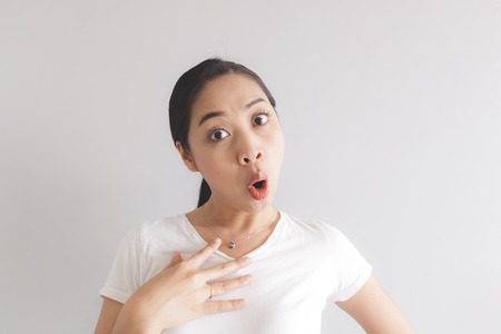 Surprised and wow face expression of Asian woman in white t-shirt. Concept of happy and impressive.の写真素材