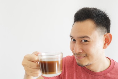 Close up of healthy Asian man offer herbal drink in a glass cup.